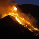 A wildfire burns in the hills on Sunday. (AP/Ringo H.W. Chiu)